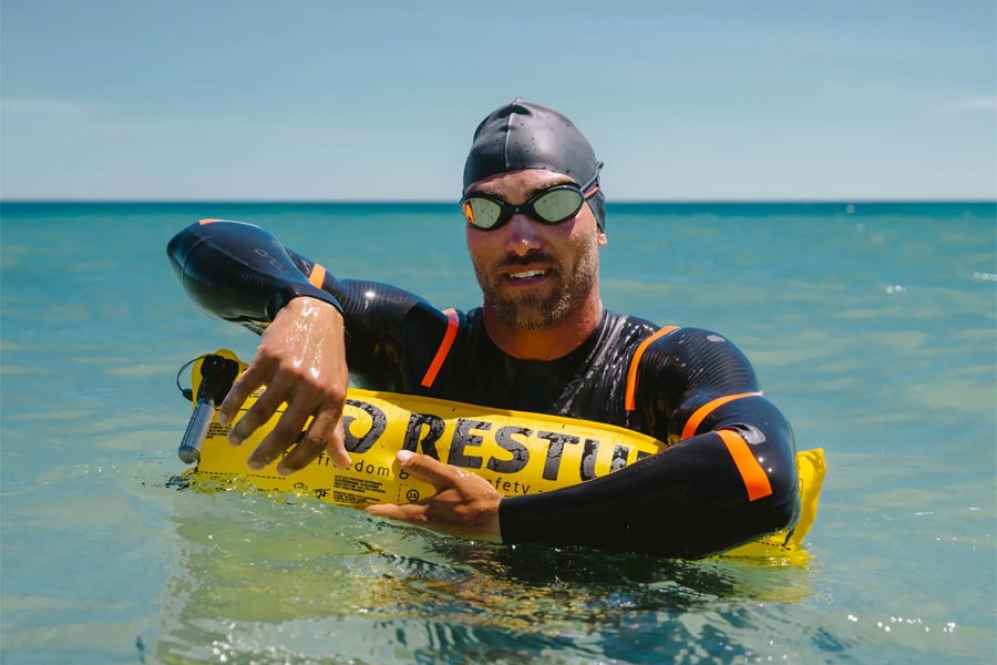 A swimmer in the ocean with a PFD (personal floatation device) to help them stay afloat while resting. This is part of Swim Safe's Life Jackets, PFD's and Life Vests range.