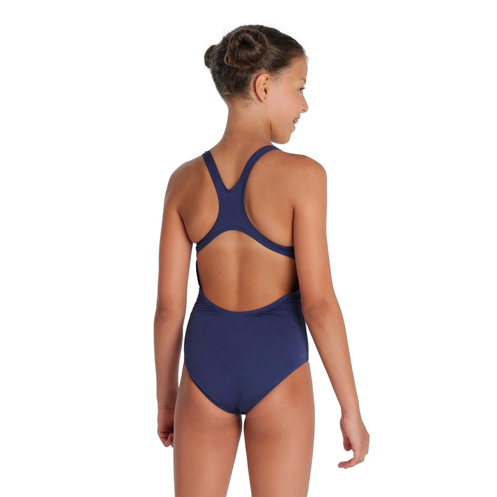 Back view of a young girl wearing a navy arena girls swimsuit.