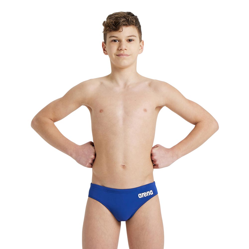 A boy wearing the royal colour arena boys team swim breifs.