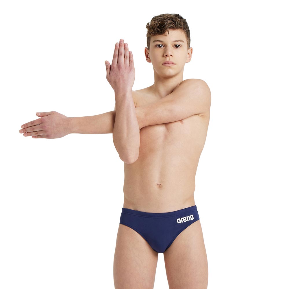 A boy wearing the arena boys team swim briefs in navy.