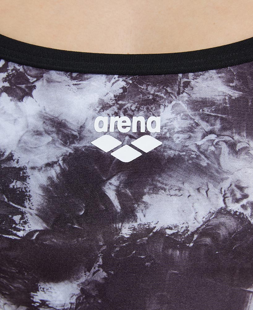 Close-up of a swimsuit with 'arena' branding on a dark patterned background