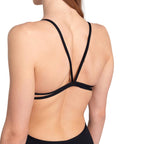 A close up back view of a woman wearing a black arena lace swimsuit.