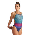 Woman wearing an arena foliage one piece swimsuit.