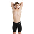 Front view of a boy wearing the arena team swim jammer in black.