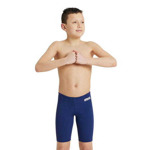 A young boy wearing the arena boys team swim jammer in navy.