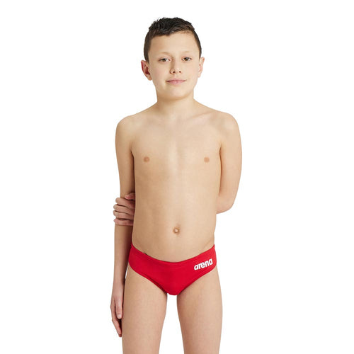 A boy wearing the arena boys team swim briefs in red.