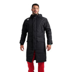 Arena unisex black long team parka jacket worn by a man in red trousers.
