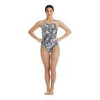 Woman wearing a black and white patterned arena swimsuit.