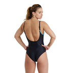 Back view of a woman wearing a black arena flora one piece swimsuit.